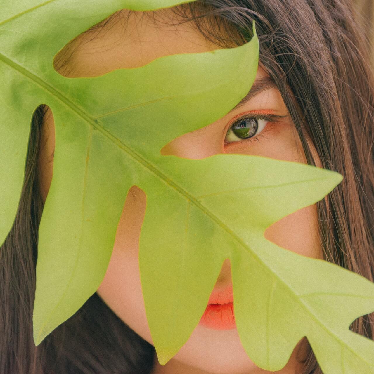 Femmes avec une feuille devant son visage